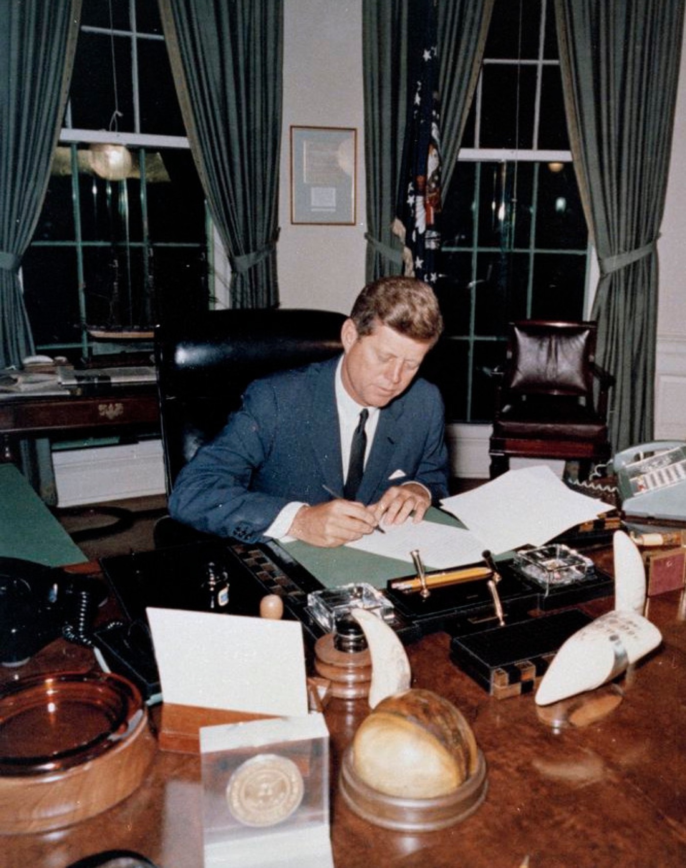 President John F. Kennedy signing Proclamation 3504, the naval quarantine of Cuba, in the Oval Office on 23 October 1962