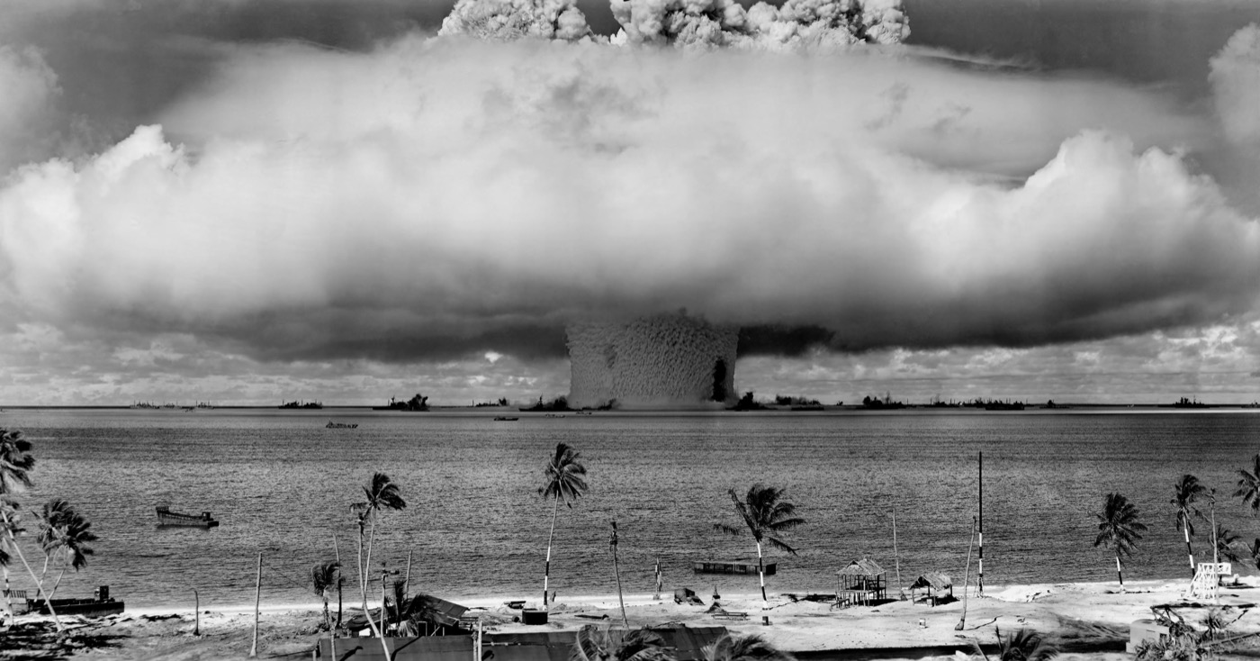 Operation Crossroads Baker — an underwater nuclear detonation at Bikini Atoll in 1946, showing an enormous column of radioactive water rising from the lagoon with warships visible at the base