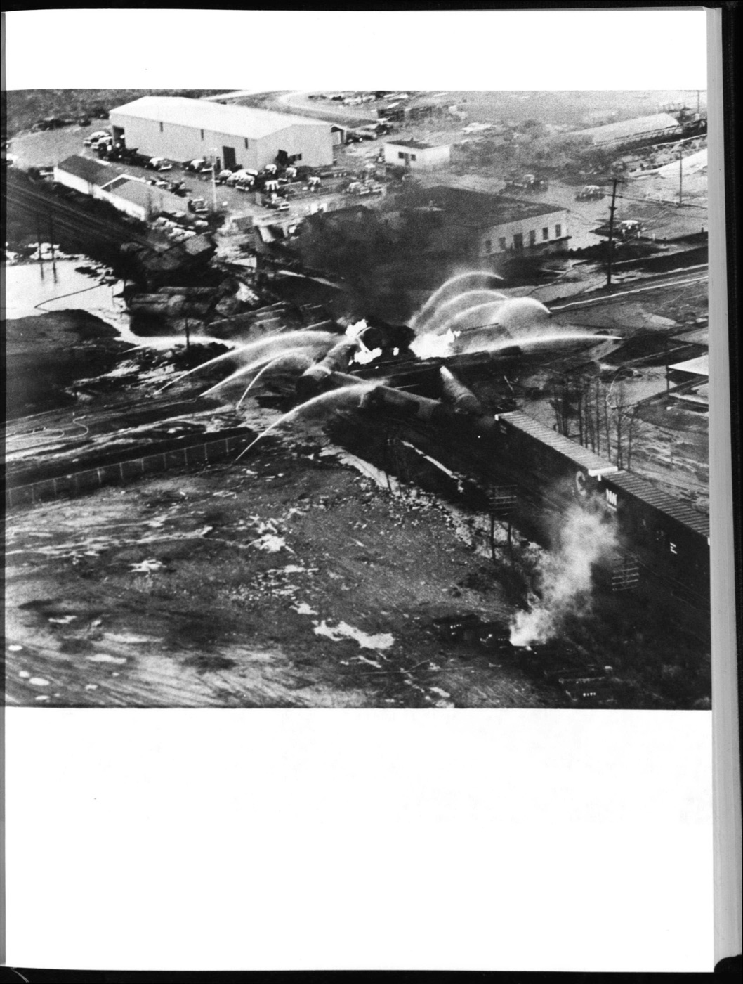 Aerial photograph showing multiple water streams from fire hoses hitting burning tanker cars at the Mississauga derailment site
