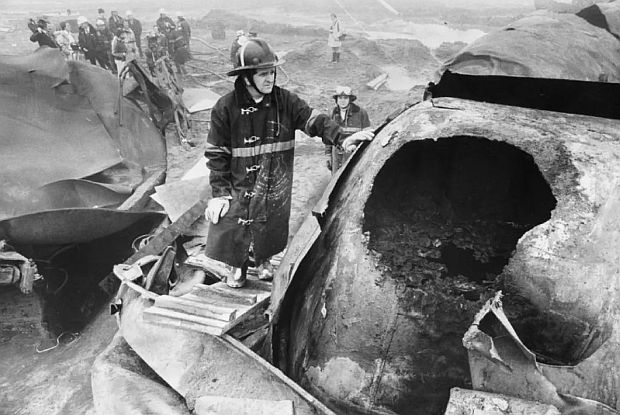 Firefighter examining the two-and-a-half-foot hole torn in the chlorine tanker car during the Mississauga derailment